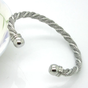 Detailed close-up of a silver twisted wire cuff bangle with woven mesh texture and ball ends