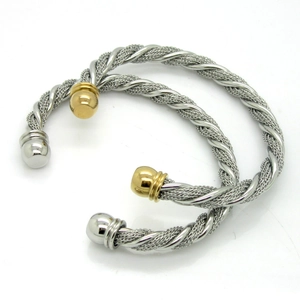 Macro shot of twisted cable cuff bracelets in gold and silver finish steel