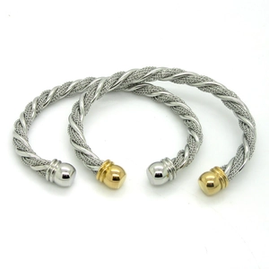 Detail of twisted cable mesh bracelets in silver and gold two-tone stainless steel