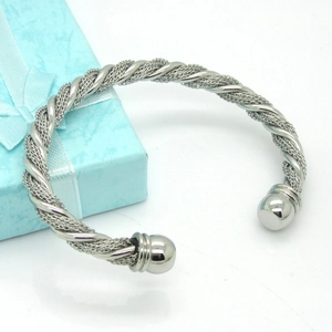 Close-up of silver braided mesh titanium steel open bangle with bead ends on blue gift box