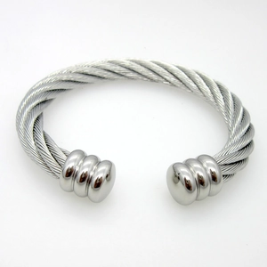 Detailed macro view of a silver stainless steel twisted cable cuff bracelet with ball ends