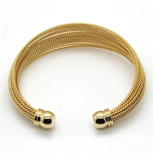 Detailed view of golden multi-layer braided stainless steel cuff bracelet with sphere tips