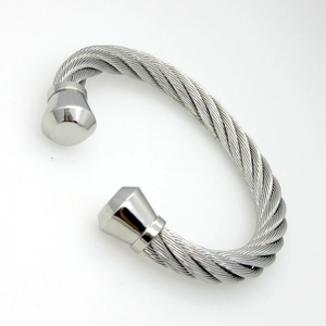 Gros plan du bracelet câble en acier torsadé argenté avec embouts coniques en métal poli