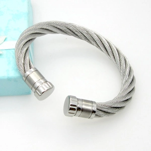 Close-up of a silver twisted cable bangle with polished ends and ribbed details
