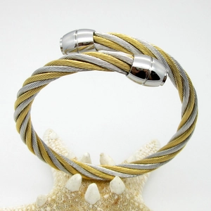 Macro detail of twisted cable open bangle featuring gold and silver textured metal wires