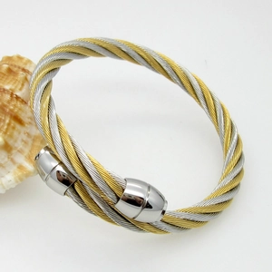 Detail of twisted cable bracelet with golden and silver steel wires and ball ends