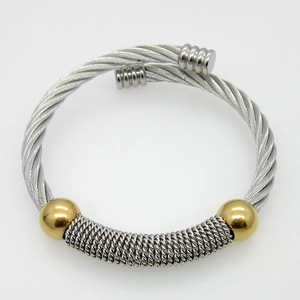 Detail of twisted cable steel bangle with silver band and gold bead accents