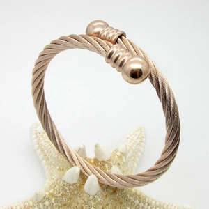 Macro detail of rose gold titanium cable twisted cuff bracelet with sphere ends