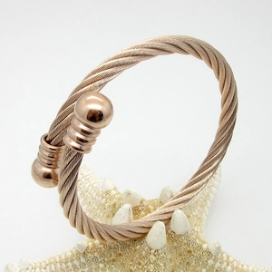 Detail of rose gold titanium twisted cable cuff bracelet with textured ball end caps