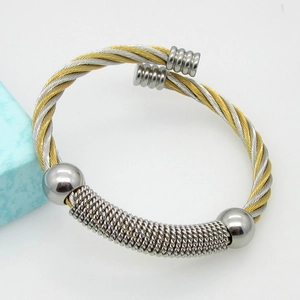 Detail of two-tone braided steel wire open bangle with silver bead accents