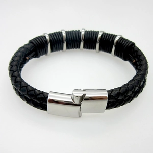 Macro detail of men's braided leather bracelet featuring polished stainless steel buckle