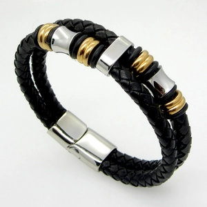 Detail of men's braided leather bracelet featuring gold and silver metal rings and magnetic clasp