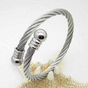 Detail of silver twisted cable bracelet with decorative spherical ends on white background