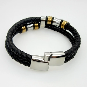 Detail of double-layer black braided leather bracelet with gold and silver magnetic clasp