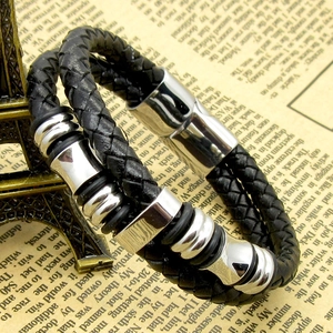 Detail of men's double-braid black leather bracelet with magnetic steel clasp and rings