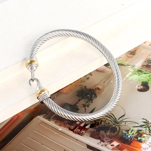 Detail of twisted cable cuff bracelet in two-tone silver and gold with hook clasp
