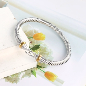 Detailed macro view of the silver cable twist bracelet with golden ring hook clasp