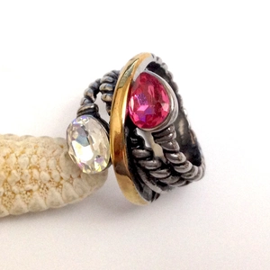 Anello bicolore in acciaio inox a spirale con cristalli a goccia su base corallo