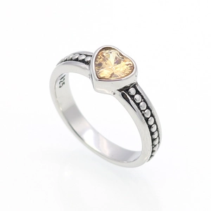 Dettaglio dell'anello in argento S925 con zircone champagne a cuore e motivi vintage