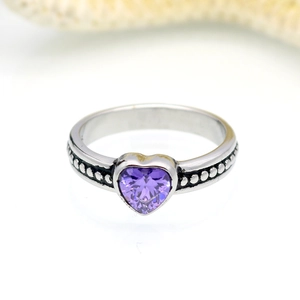 Dettaglio anello con zircone viola a cuore e fascia argentata con rilievi a microsfere