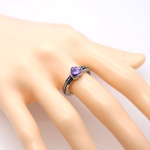 Dettaglio dell'anello a sfere in argento con zircone viola a cuore su un modello