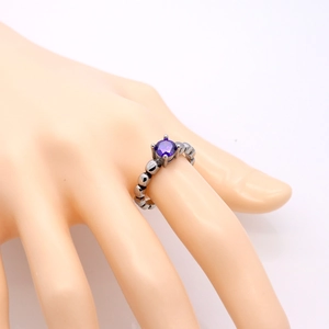 Vintage roestvrijstalen ring met ronde paarse zirkoon en kralenband aan hand