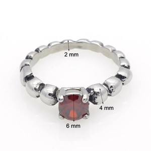 Macrodetail van retro roestvrijstalen ring met rode zirkoon en exacte afmetingen