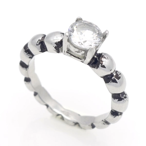 Gedetailleerd zicht op vintage zilveren ring met kralenband en klauwgezette zirkoonsteen