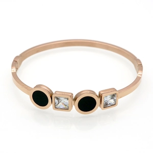 Detail of rose gold open bangle with black round inlays and square cubic zirconia stones