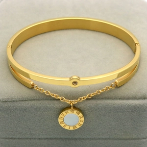 Detailopname van gouden hanger met Romeinse cijfers en wit parelmoer op de armband