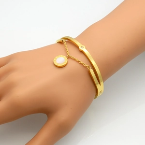 Detailopname van een dubbellaagse gouden armband met Romeins parelmoer hangertje