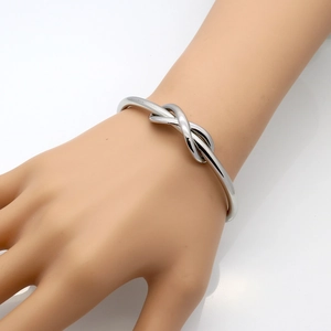 Polished stainless steel knot bangle with a minimalist infinity design for women