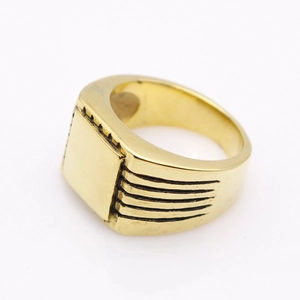 Detail of gold square signet ring showing polished flat top and side grooves on metal