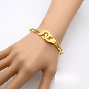 Minimalist gold stainless steel handcuff link bracelet shown on a hand model