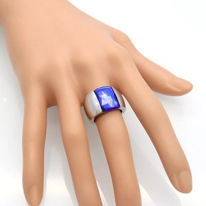 Detailed macro view of a blue rectangular cut gemstone set in a wide silver steel ring band