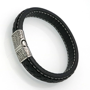 Detail of black braided leather bracelet with silver magnetic clasp featuring Greek key patterns