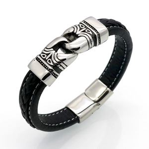 Detail view of woven black leather bracelet with vintage engraved silver metal clasp