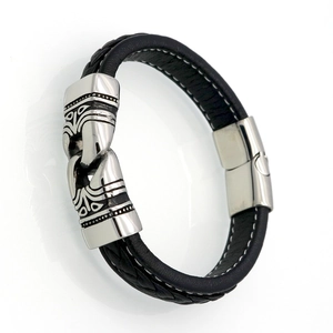 Detail of men's black braided leather bracelet with engraved stainless steel magnetic clasp