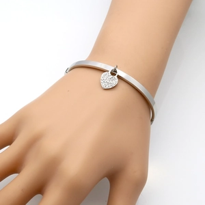 Bracelet jonc argenté avec pendentif cœur serti de diamants pavés, vue de profil à 45 degrés
