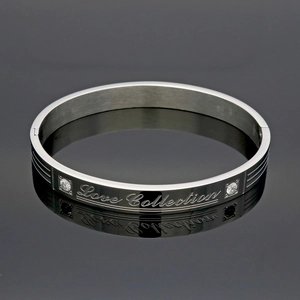 Detail of silver titanium steel bracelet with Love Collection engraving and cubic zirconia