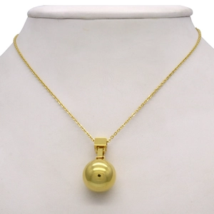 Gedetailleerd beeld van een gepolijste gouden bal hanger ketting op een display