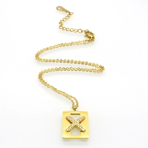 Detailed view of gold rectangle pendant with crystal X element and lobster clasp chain