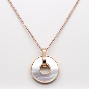 Detailed macro view of a round white mother of pearl pendant on an 18K rose gold chain