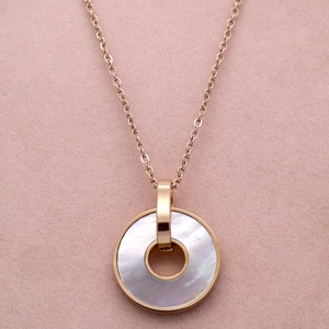 Macro detail of round white mother-of-pearl inlay on elegant 18K rose gold necklace