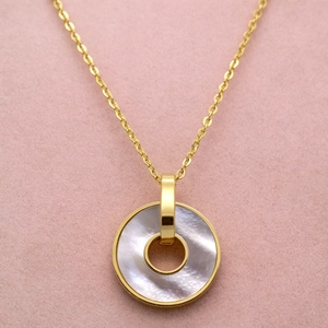 Macro detail of round white mother of pearl pendant on 18K rose gold necklace chain