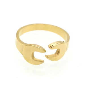 Macro shot of gold wrench shaped open ring with polished finish and industrial design