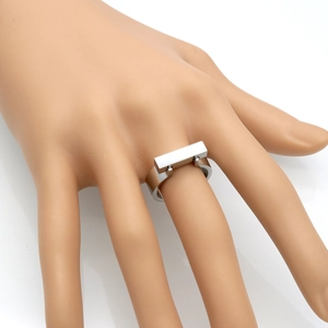 Macro detail of a silver rectangular block ring with a polished stainless steel finish