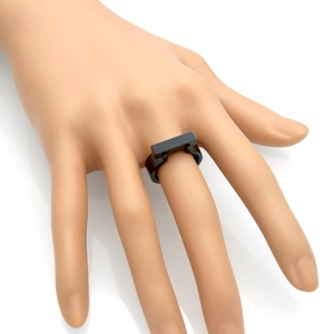 Close-up of a minimalist black square ring in polished titanium steel worn on finger