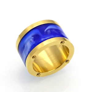 Macro detail of gold stainless steel ring with deep blue marble resin and rivet accents