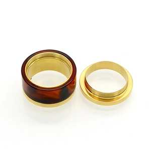 Macro shot of titanium steel ring with brown resin inlay and screw thread details